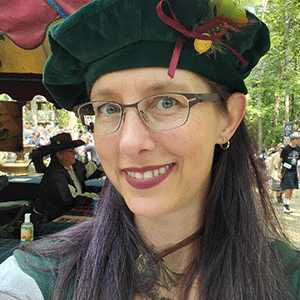 Margaret Boas wearing a green hat with a purple ribbon and green feather