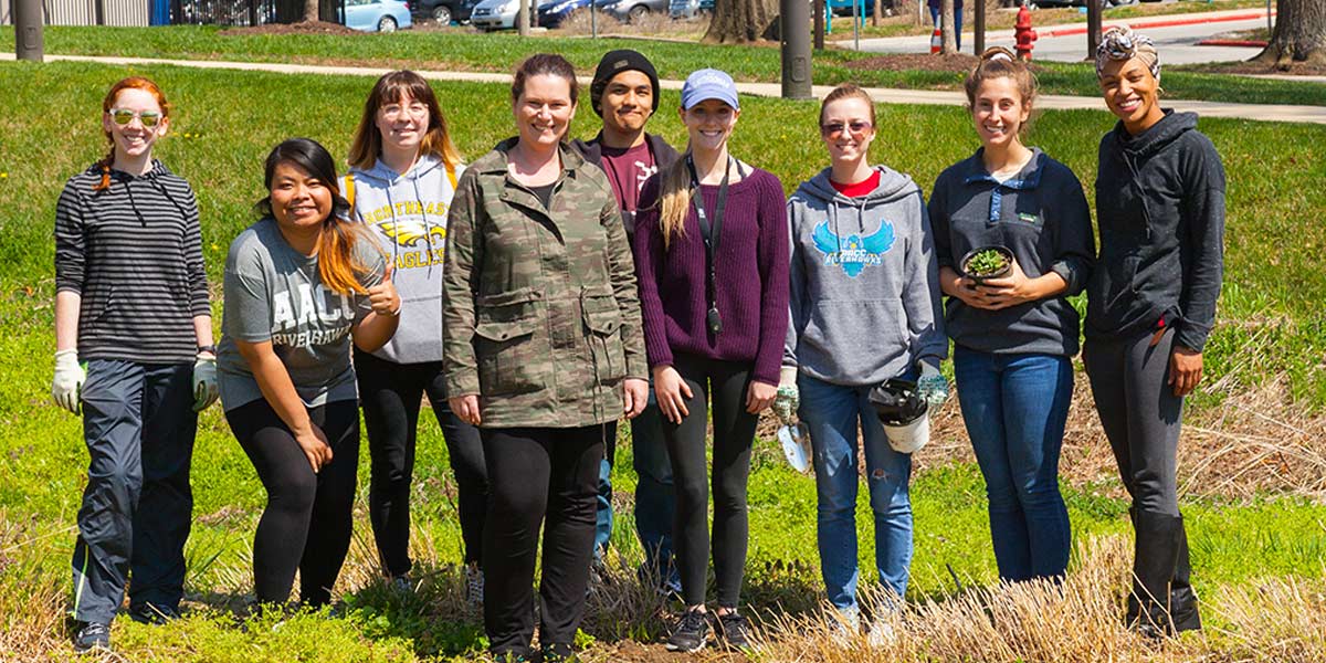 Campus ambassadors stand in front of the rain garden