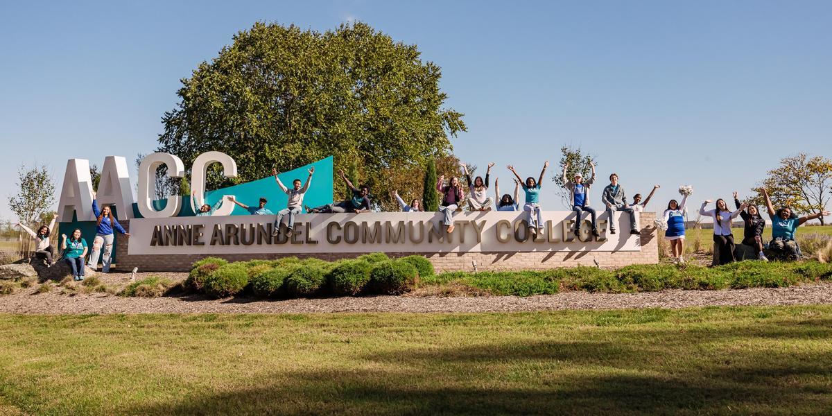 AACC Entrance Sign with students surrounding it.