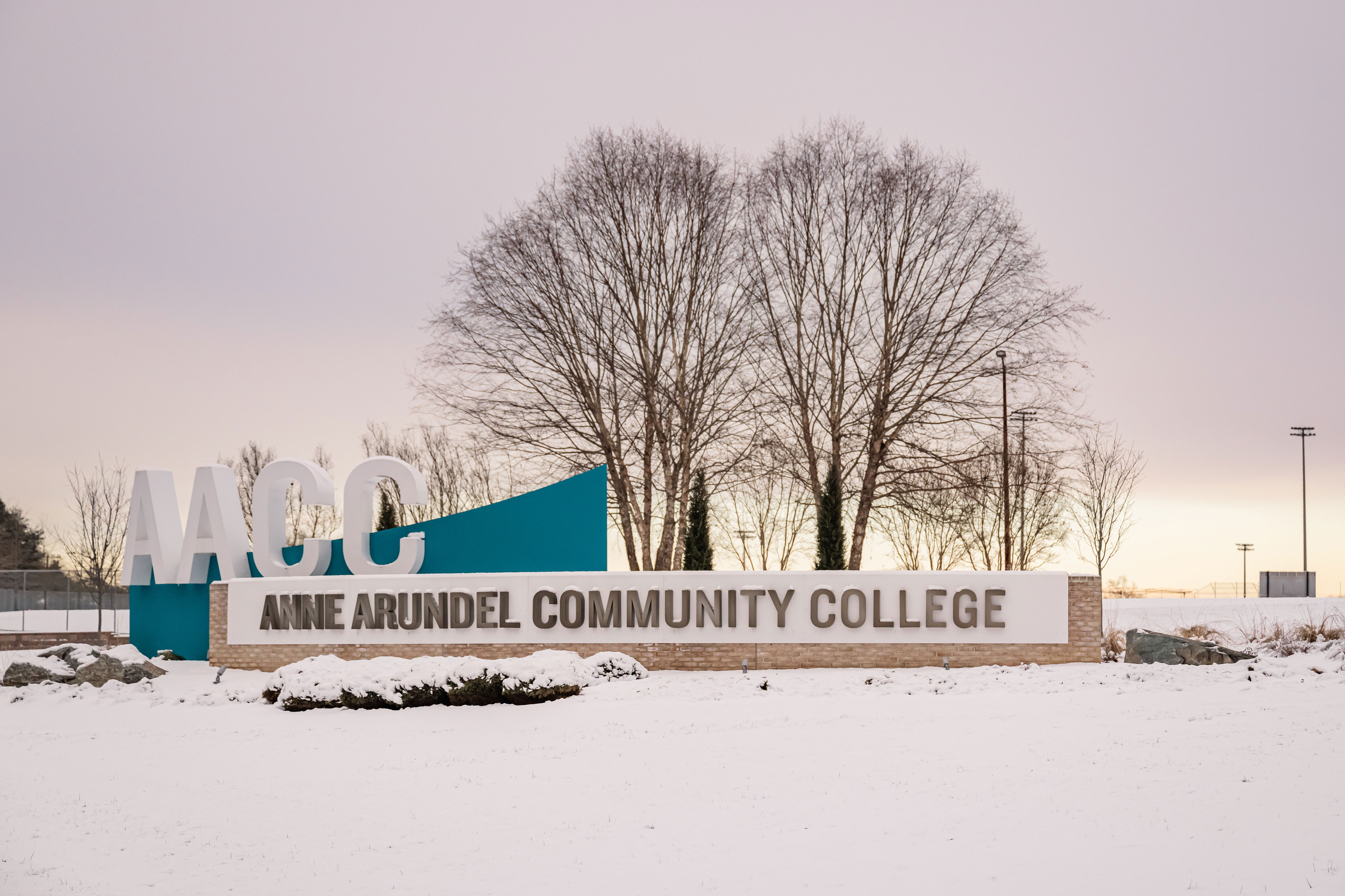 Entrance of AACC with the AACC sign and snow on the ground.