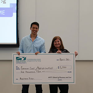 Common Goal/Ball at the Mall pitcher holding a large check with Stephanie Goldenberg