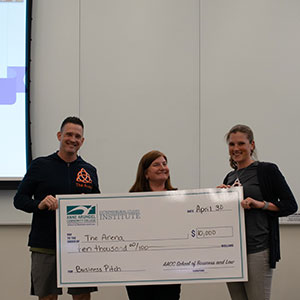 The Arena pitchers holding a large check with Stephanie Goldenberg