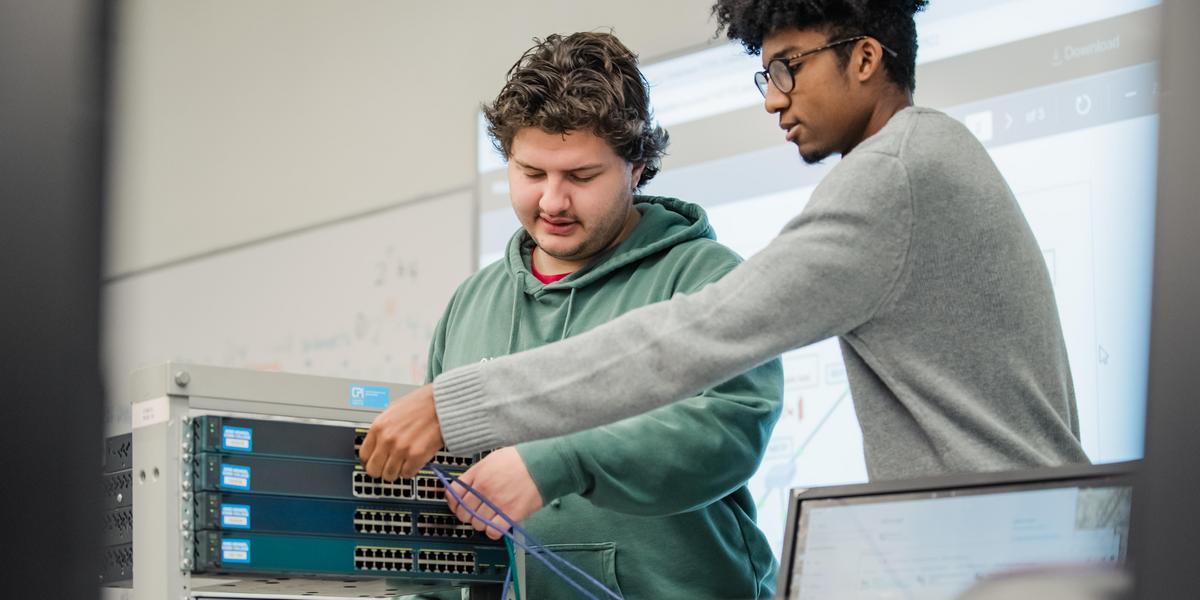 Multiple students working on technical equipment.