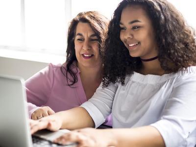 Mom and student look at computer.